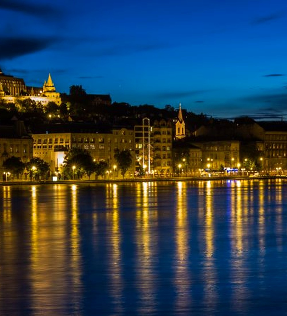 Budapest glowing along the Danube at blue hour