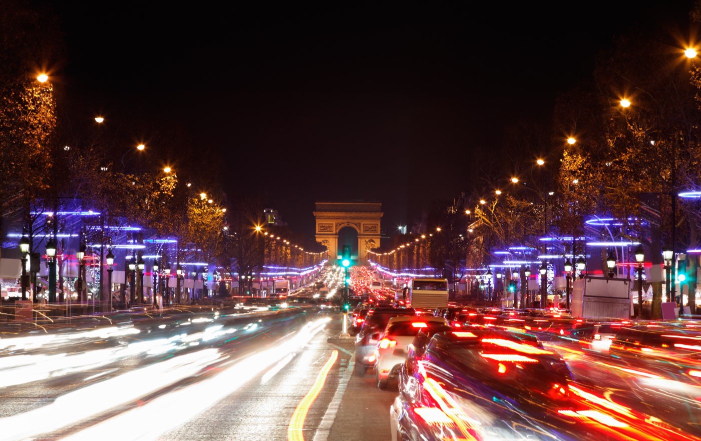 The Champs-Elysees illuminated at night with the Arc de Triomphe ahead