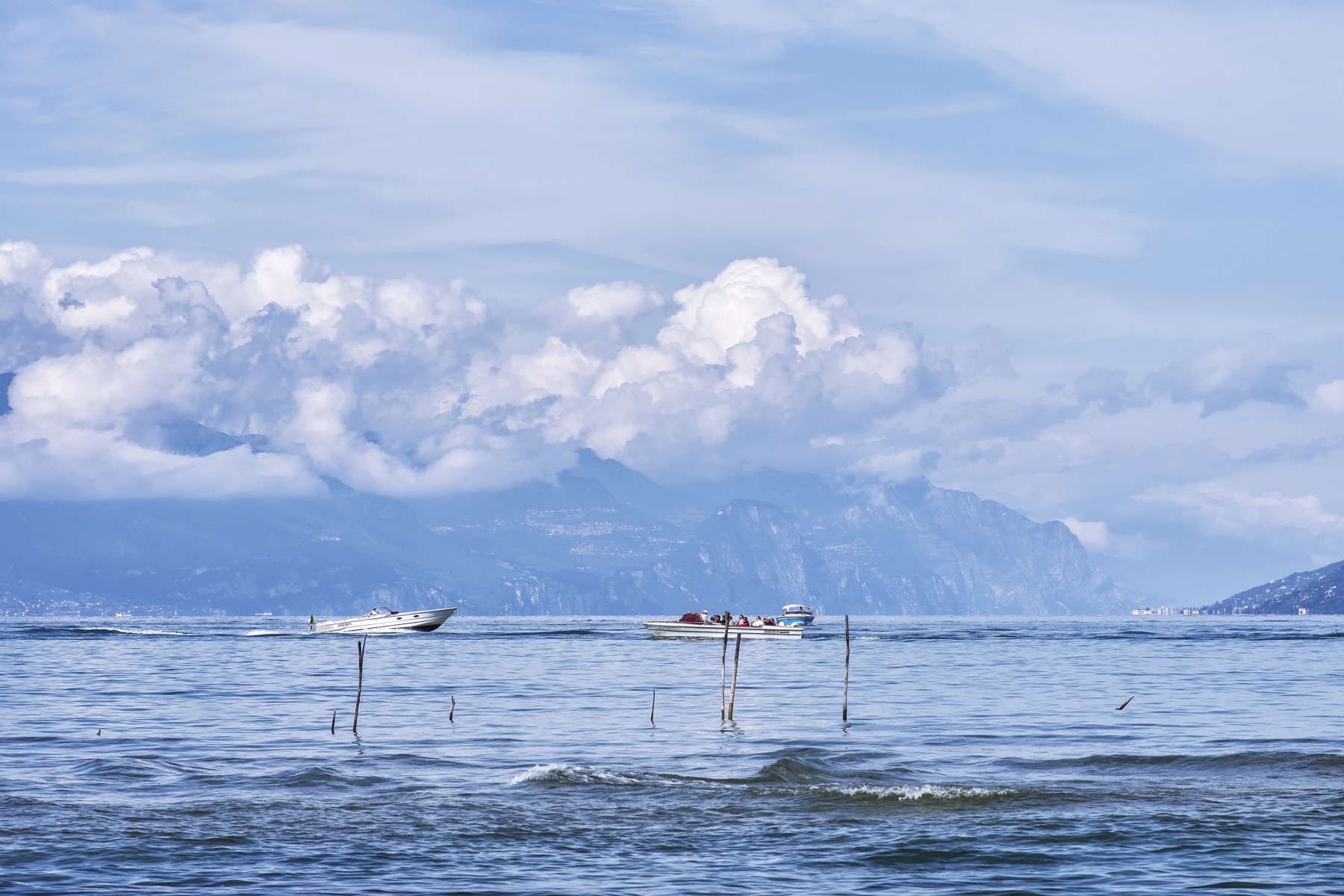 Boats and mountains viewed across Lake Garda