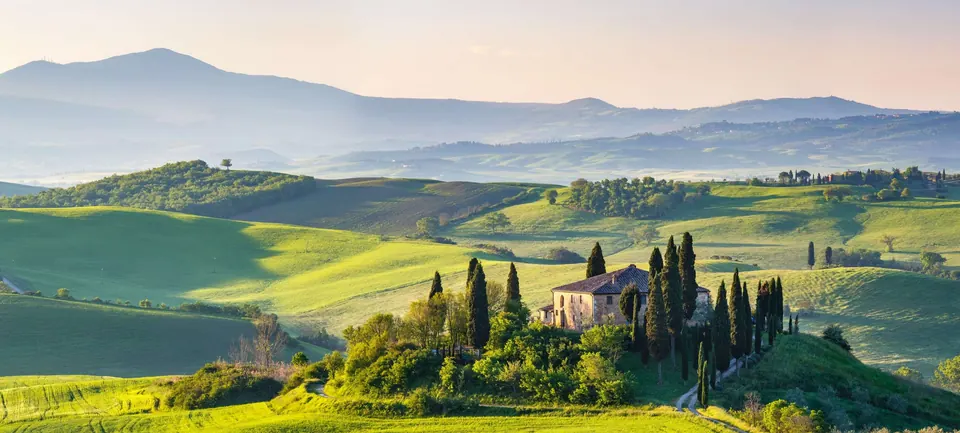 Tuscan hills, cypress trees and a farmhouse in soft winter light